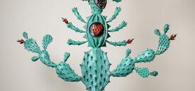 Totem-esque light green cacti with faces interspersed within the body.